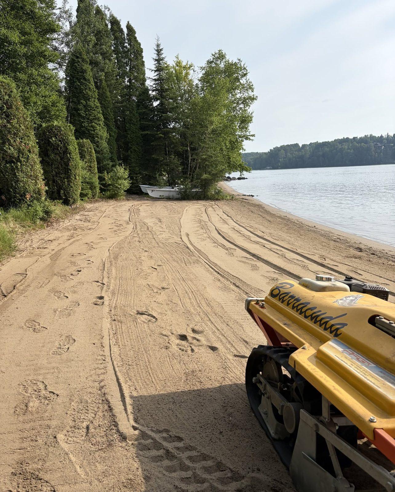 Tamisage en cours : les chenilles de la machine laissent des traces dans le sable déjà travaillé.